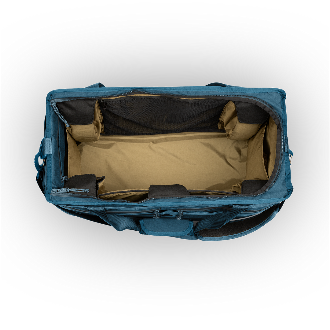 58L Mission Hauler Tote (Wander Blue) with main compartment open showing Coyote interior and pockets on a white background / Wander Blue
