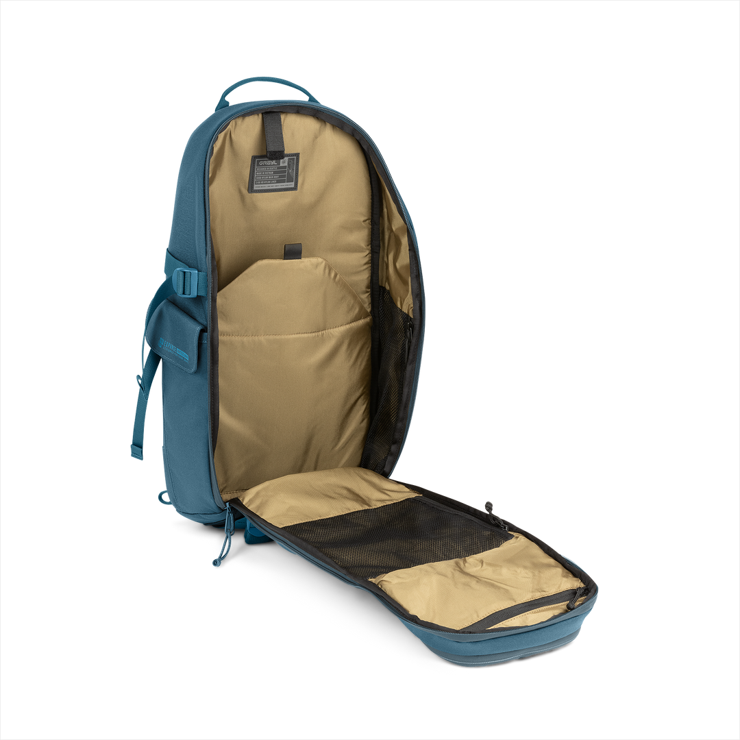 18L Transport Sling Daypack (Wander Blue) with open compartment showing Coyote interior on a white background / Wander Blue