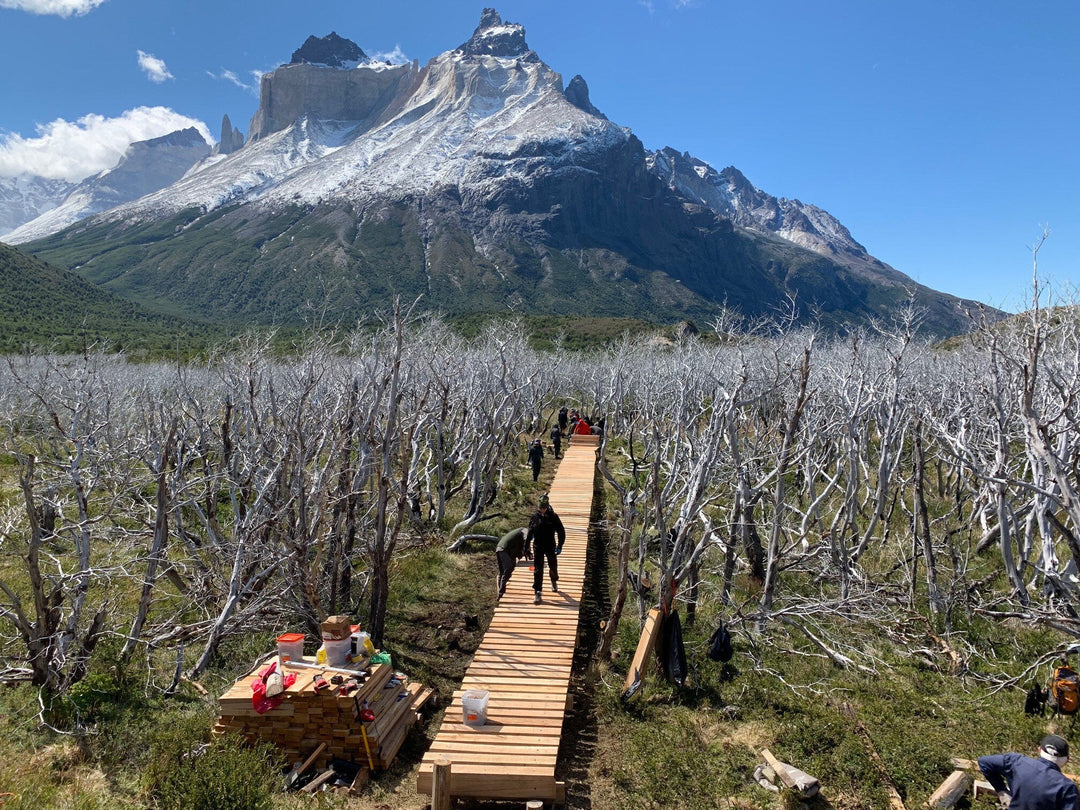 Freiwillige des Adventure Travel Fund bauen eine Brücke in einer malerischen Berglandschaft.